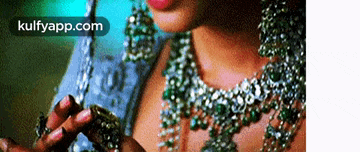 a close up of a woman wearing a necklace and earrings with the words kulfyapp.com on the bottom