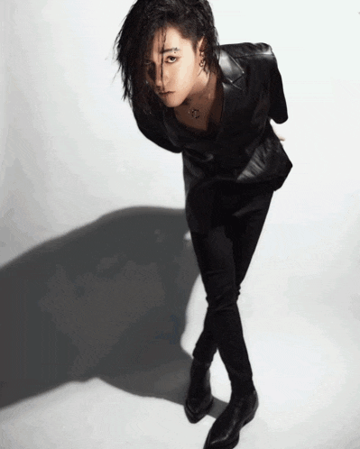 a woman in a black leather jacket and black pants