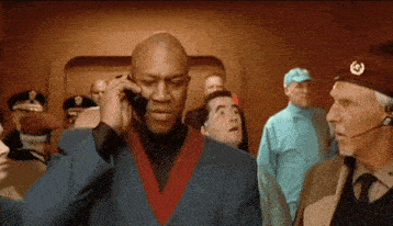 a man is talking on a cell phone in front of a crowd