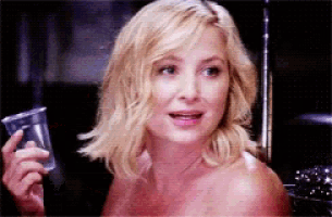 a woman without a shirt is holding a cup in her hand
