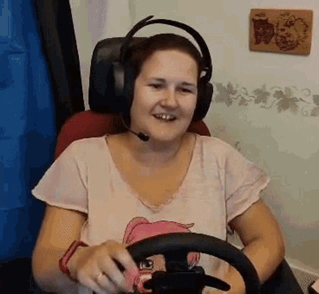 a woman is wearing headphones and holding a steering wheel .