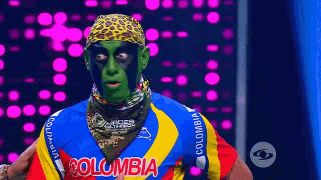 a man with green paint on his face is wearing a shirt that says colombia