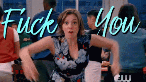 a woman with a surprised look on her face is sitting in front of a sign that says " fuck you "