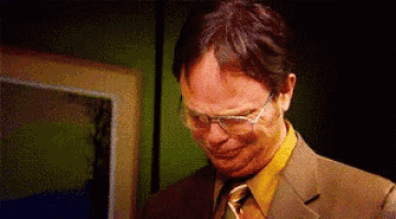 a man wearing glasses and a suit is making a funny face .