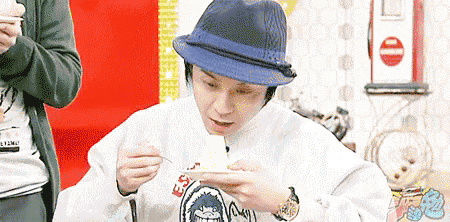 a man wearing a hat is eating something with a fork and spoon .