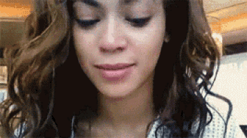 a close up of a woman 's face with curly hair .