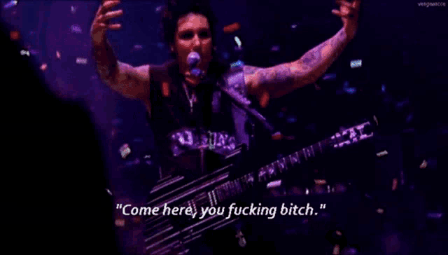 a man singing into a microphone while holding a guitar with the words come here you fucking bitch written below him