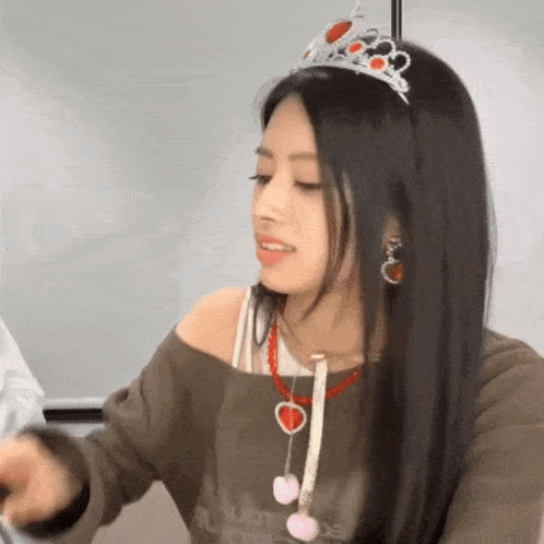 a girl wearing a tiara and a necklace with hearts on it