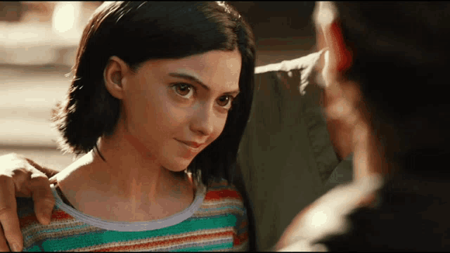 a woman in a striped shirt looks at a man