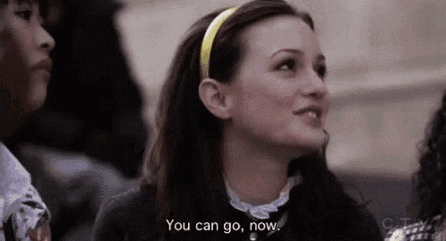 a woman wearing a yellow headband is smiling and talking to another woman .