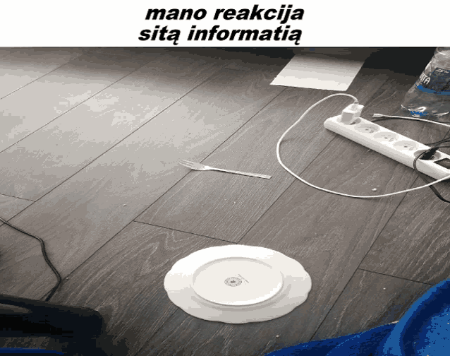 a white plate with a fork on it sits on a wooden floor next to a bottle of water
