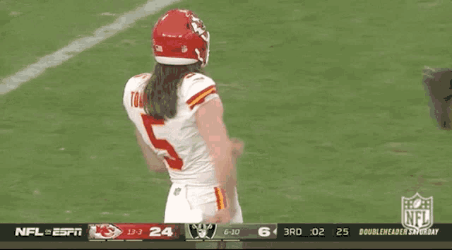 a football player wearing a number 5 jersey stands on the field