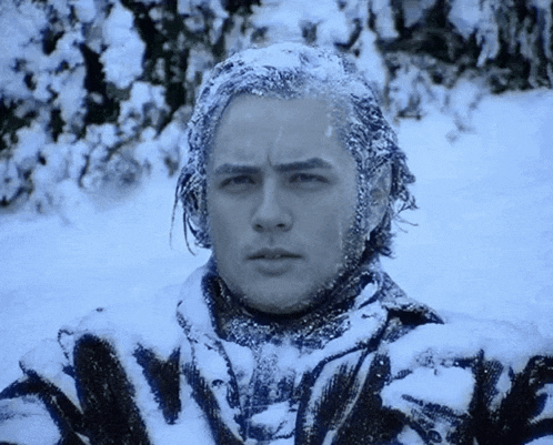 a man is covered in snow and ice and looks at the camera