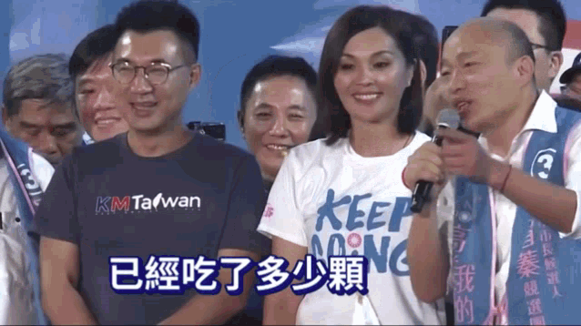 a woman in a keep going shirt stands in front of a crowd of people
