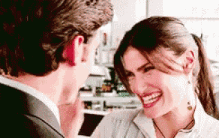 a man and a woman are laughing together and the woman is smiling .