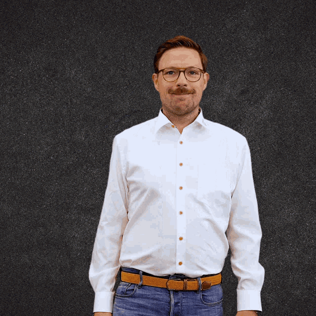 a man wearing glasses and a white shirt points up with his finger