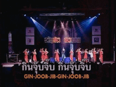 a group of people singing on a stage with the words gin-joob-jib-gin-joob-jib in blue
