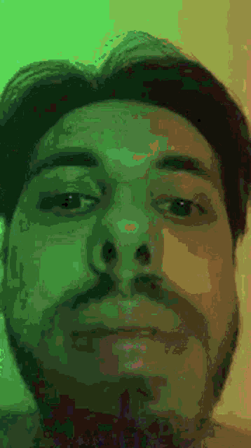 a close up of a man 's face with a green and yellow background