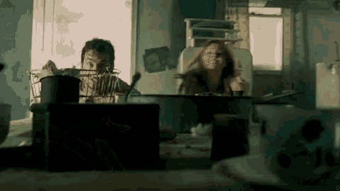 a man and a woman are sitting at a table with a bowl of food .