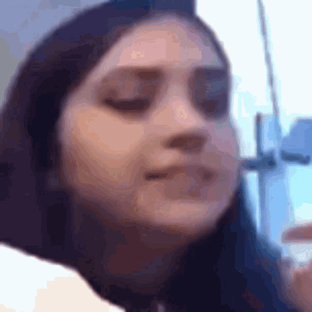 a woman with her eyes closed looks at the camera