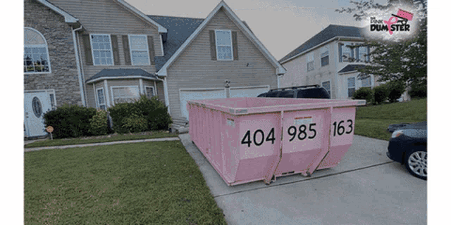 a pink dumpster in front of a house with the number 404 on it