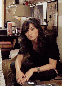 a woman sitting on a couch with the word duh on a laptop