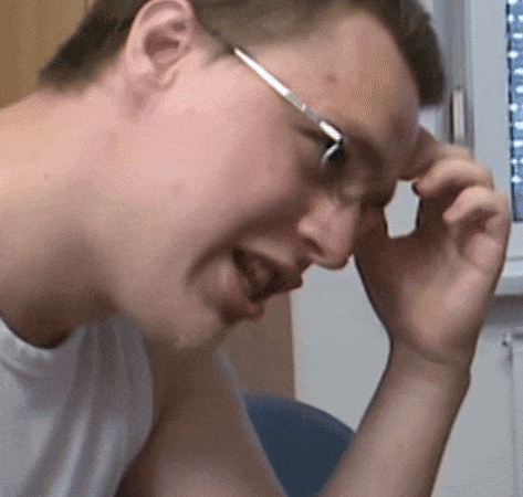 a man wearing glasses is scratching his head