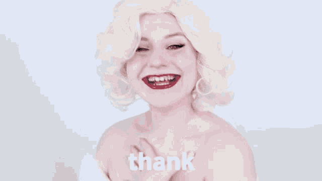 a woman with blonde hair and red lipstick is smiling and says thank