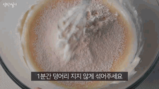 a person is whisking a mixture in a bowl with flour .