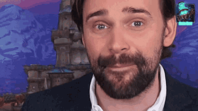 a man with a beard in front of a castle