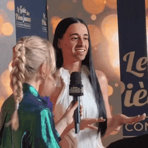 a woman is being interviewed by a young girl while holding a microphone .