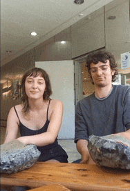 a man and a woman sit at a table with rocks on it