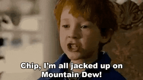 a young boy with red hair is sitting in a chair and talking to someone .
