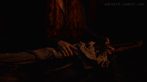 a woman with long red hair is standing in a dark room with the website p3ns1v3.tumblr.com