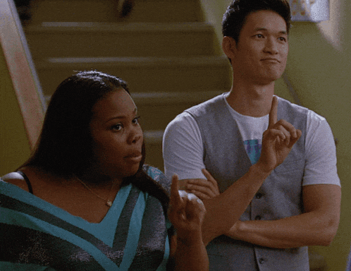 a man and a woman are standing next to each other on a set of stairs