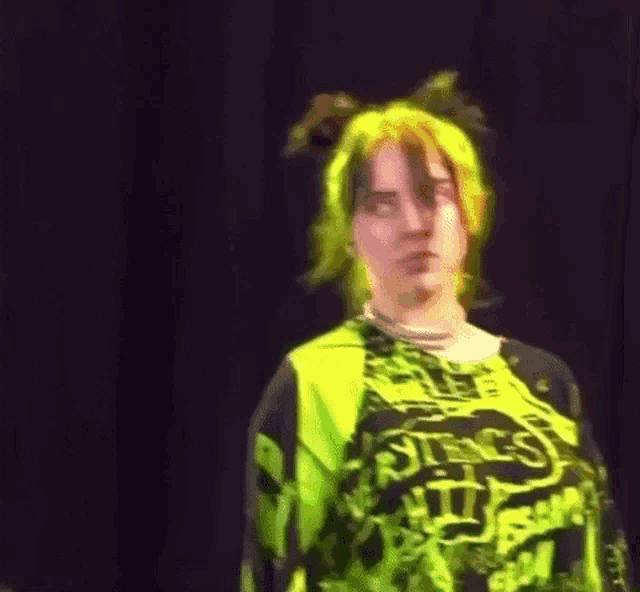 a close up of a person wearing a neon green shirt and a black shirt on a stage .