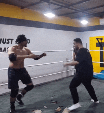 two men in a boxing ring with a wall that says just do it
