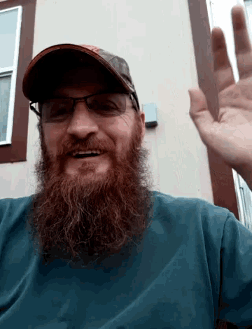 a man with a long beard wearing glasses and a hat