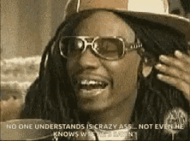a man wearing sunglasses and a hat is laughing and saying `` no one understands is crazy ass .