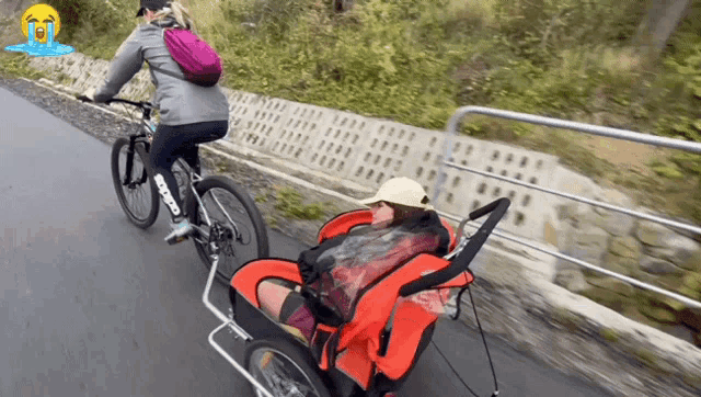 a woman riding a bike with a child in a stroller