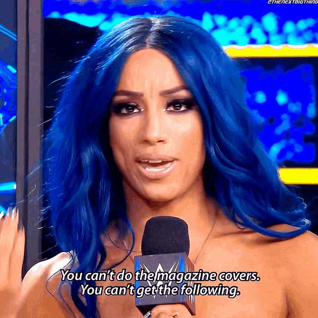 a woman with blue hair is talking into a microphone and says you can 't