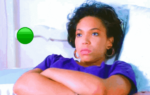 a woman in a purple shirt is laying in a hospital bed