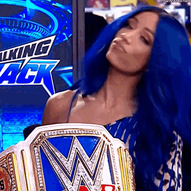 a woman with blue hair is holding a wrestling title