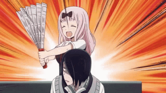 a girl is holding a fan while sitting on a man 's shoulders .