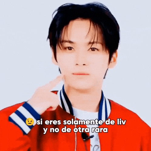 a young man wearing a red jacket is pointing at his face and says si eres solamente de liv y no de otra rara