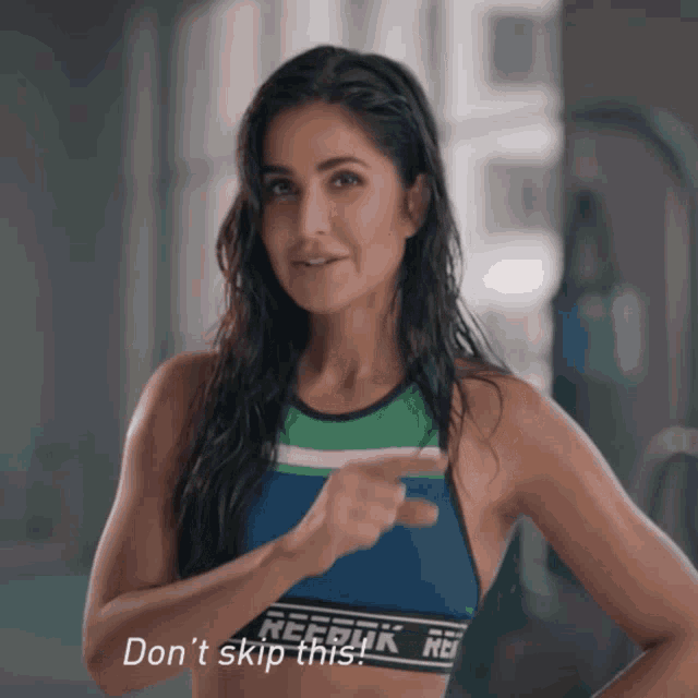 a woman wearing a reebok top is pointing