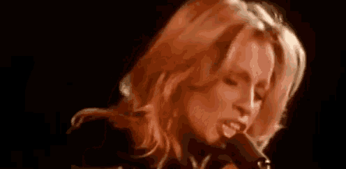 a close up of a woman singing into a microphone on stage .
