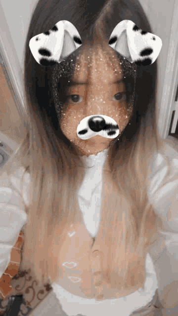 a girl with dalmatian ears on her face is taking a selfie