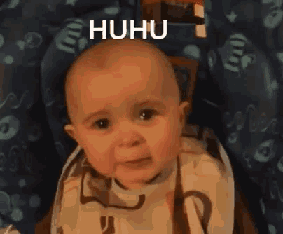 a baby is sitting in a high chair with the word huhu written on it