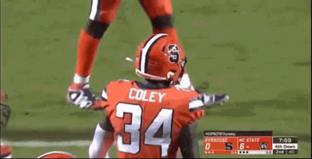 a football player wearing a number 34 jersey is being tackled by another player